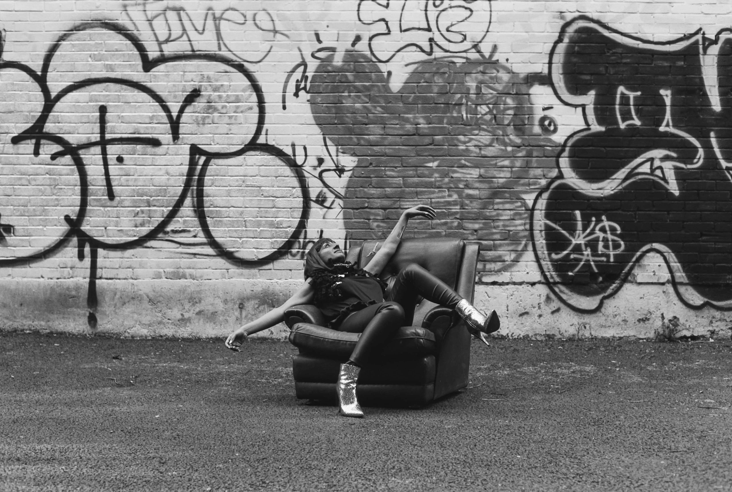 woman-in-armchair-by-graffiti-wall-black-and-white-photograph